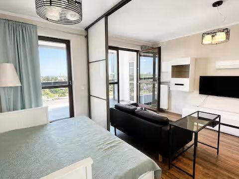 Actual apartment living space with a sofa, large windows and glass bedroom divider